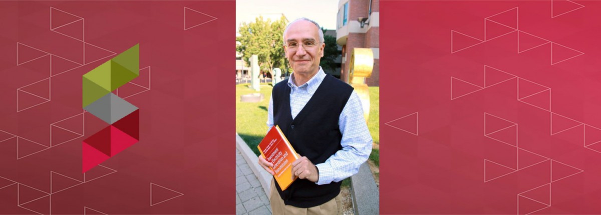 Ohio State Electrical and Computer Engineering (ECE) Professor Antonio Conejo holding a textbook outside