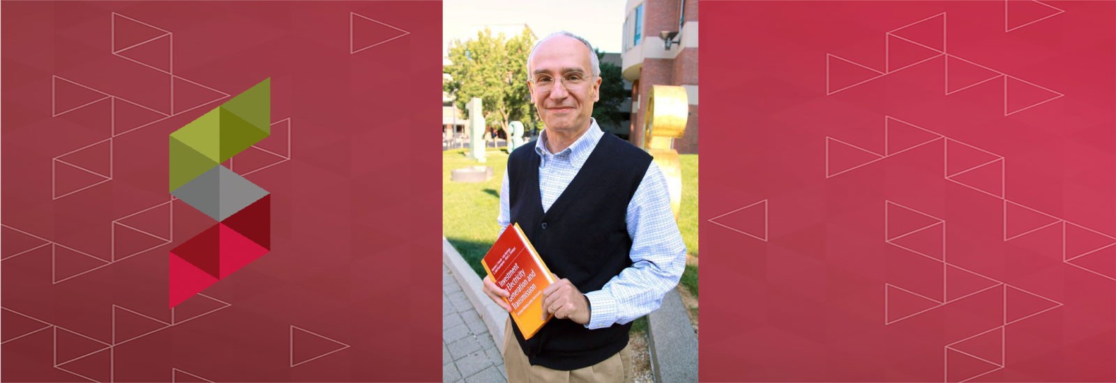 Ohio State Electrical and Computer Engineering (ECE) Professor Antonio Conejo holding a textbook outside