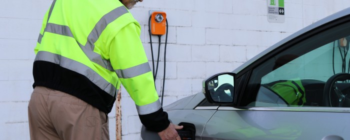 man plugging in an electric vehicle