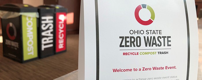 sign saying Zero Waste with compost, trash and recycling bins in background