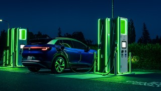Electric vehicle at a glowing charging station at night  