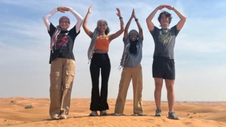 Students spelling Ohio with their arms standing in the desert.