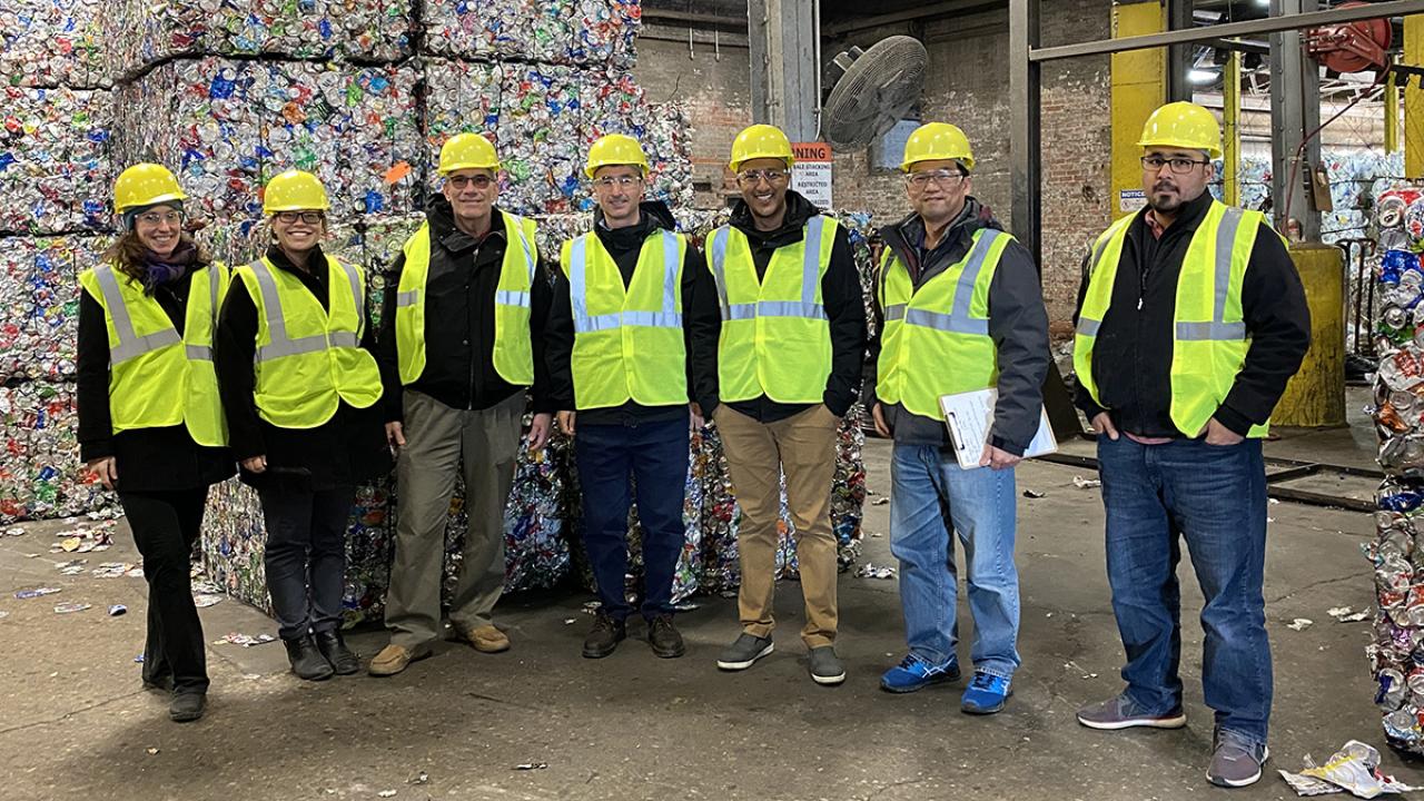 Tour group in front of bales of aluminum cans