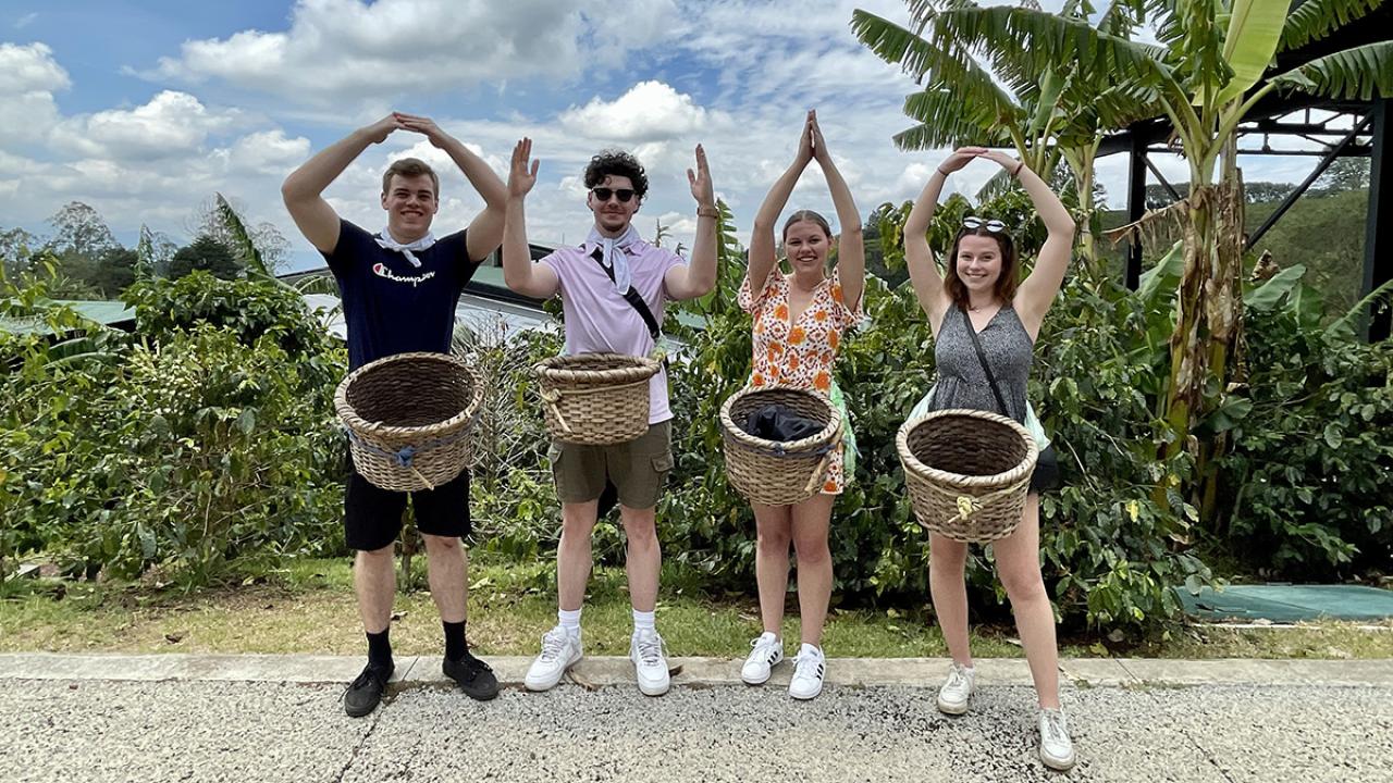 Students spelling Ohio with arms near palm trees